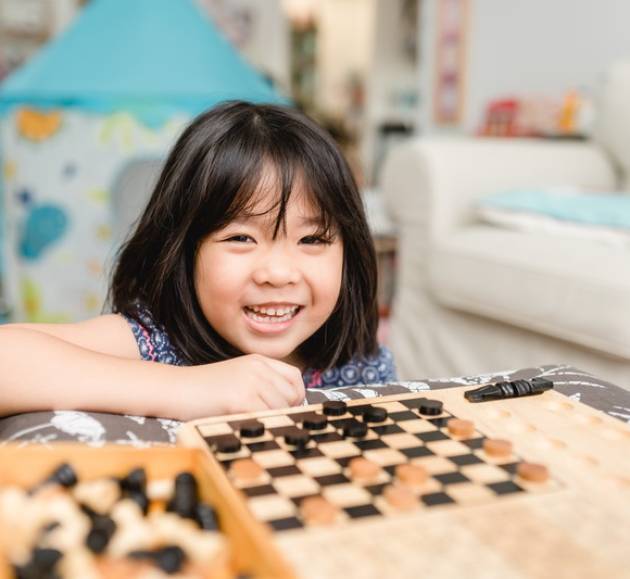 Asian kid girl and mother stay at home lockdown from covid-19 coronavirus crisis are playing chess while spending time together at home.Smart kid home school kid with mom.Stay home Stay safe with mom.